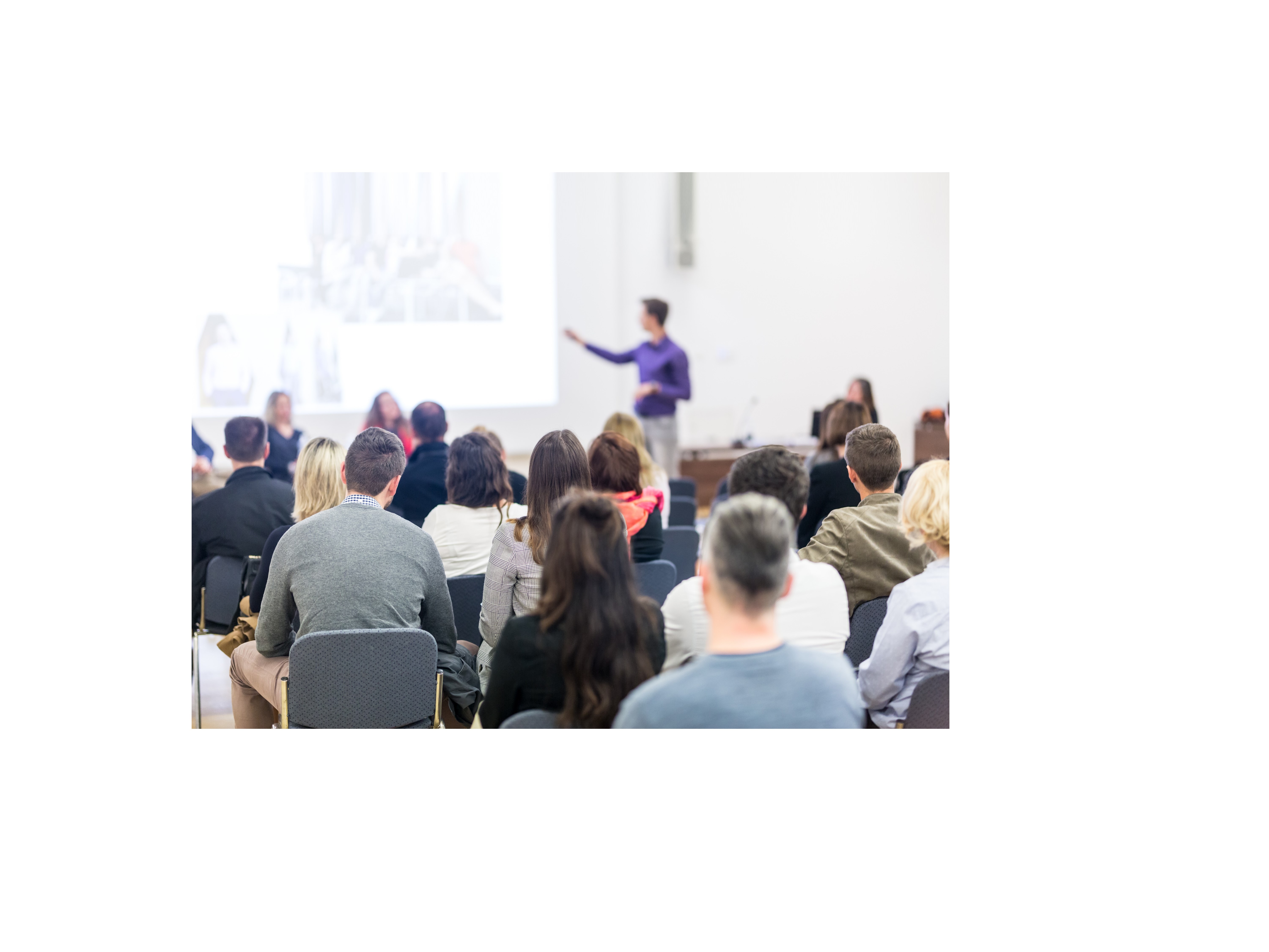 Image of man pointing at a presentation screen with people in the audience watching